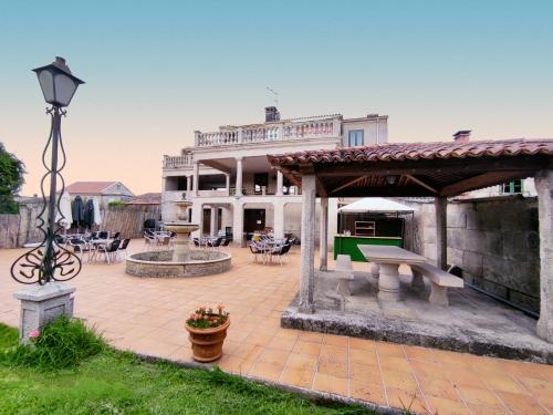 a large house with a picnic table and a fountain at Albergue Villa San Clemente in Tui
