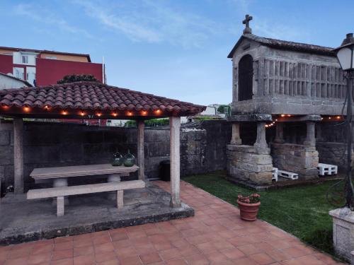 a wooden bench sitting under a gazebo at Albergue Villa San Clemente in Tui