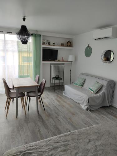 une chambre avec un lit, une table et des chaises dans l'établissement Appartement climatisé avec balcon,wifi, proche remparts, à Avignon
