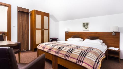 a bedroom with a bed and a desk and a chair at Penzion Chopok - Apartments in Liptovský Mikuláš