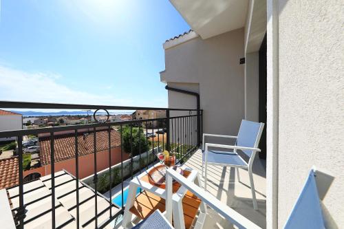 a balcony with a blue chair and a table at Luxury Aparthotel Zadar in Zadar