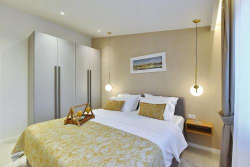 a bedroom with a large bed and two lights at Luxury Aparthotel Zadar in Zadar