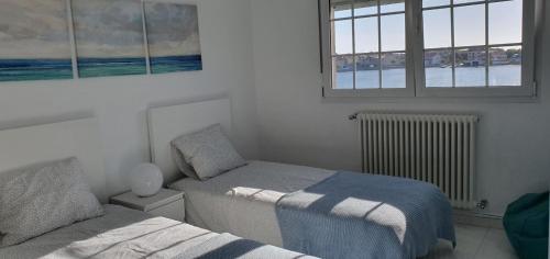 sypialnia z dwoma łóżkami i oknem w obiekcie APARTEMENTOS PASEO DE LORDELO - 2 Derecha w mieście O Grove