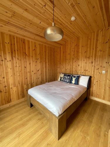 a bedroom with a bed in a wooden room at Southern County Resort in Sheean