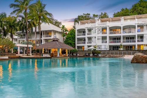 une grande piscine en face d'un hôtel dans l'établissement Beach Club Palm Cove 2 Bedroom Luxury Penthouse, à Palm Cove