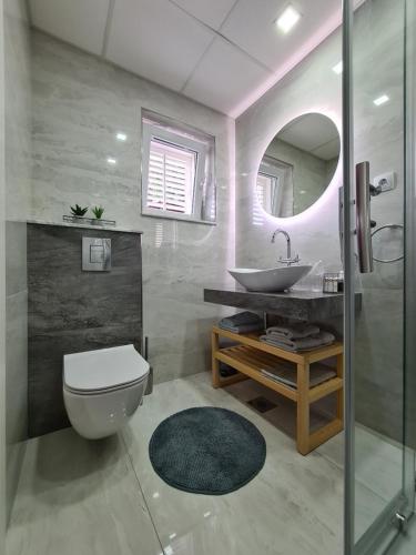 uma casa de banho com um lavatório, um WC e um espelho. em Bed and Breakfast Villa Klaic em Dubrovnik