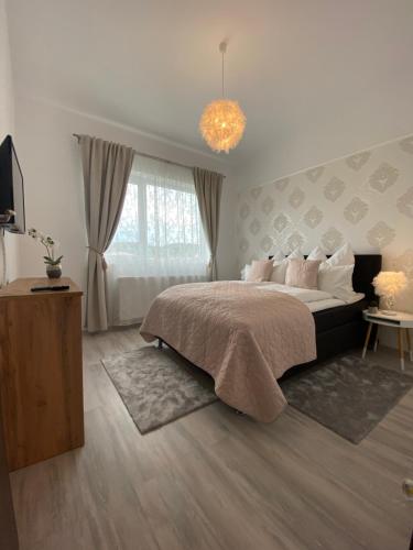 a bedroom with a large bed and a chandelier at Holiday House Rasnov in Râşnov