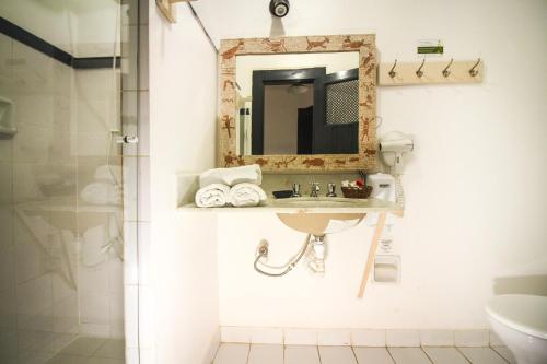 a bathroom with a sink and a mirror at Pousada Bartholomeu in Paraty