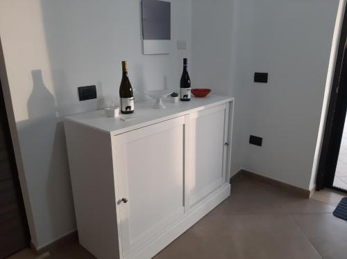 a white cabinet with two bottles of wine on it at B&B CASA MARTINA in Giungano