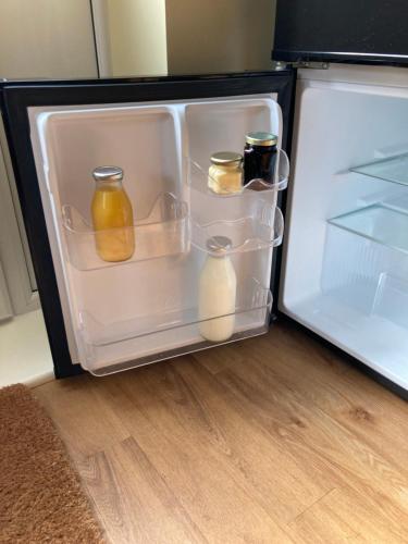 um frigorífico aberto com frascos e leite em The Buttery em Brundall