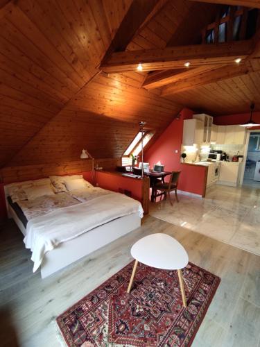 ケストヘイにあるJoel Swiss Apartmanのベッドルーム1室(ベッド1台、テーブル付)
