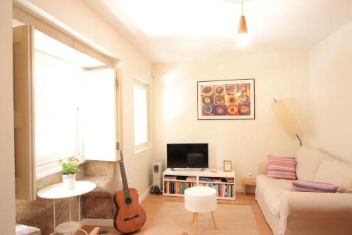 a living room with a guitar and a couch at Casa S. Miguel 6 in Porto