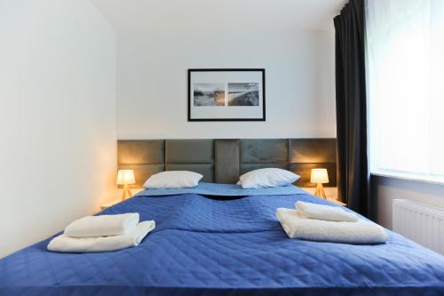 a large blue bed with two white pillows on it at M&K Apartament Słomkowe Kapelusze - Sobieszewo, Wyspa Sobieszewska in Gdańsk