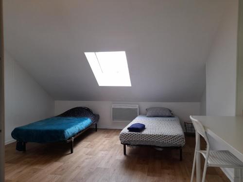 une chambre avec deux lits et une fenêtre dans l'établissement LOGEMENT VERT proche de NEOMA et de la CATHEDRALE de REIMS, à Reims