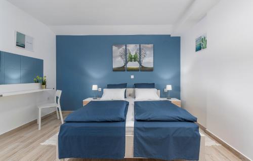 a blue bedroom with a bed and a desk at Apartment Maria in Vodnjan