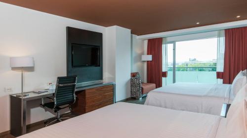 Una habitación de hotel con dos camas y un televisor. en Holiday Inn Mexico Zona Centro by IHG, en Ciudad de México