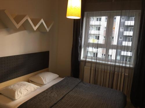 a bedroom with a bed and a window at Apartament Stanczyka 2 in Warsaw