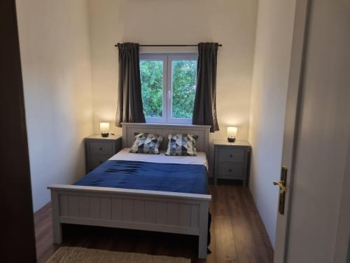 um quarto com uma cama com lençóis azuis e uma janela em Vintage Resort em Sarud