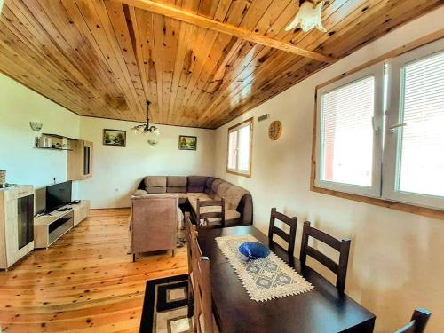 a living room with a table and a couch at Durmitorski konaci apartments in Žabljak