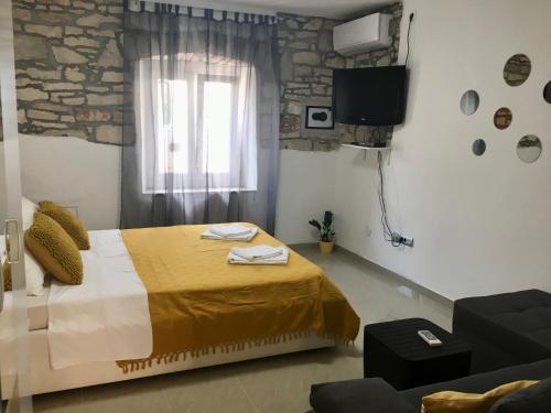 a bedroom with a bed and a window and a couch at Apartments Eni & Dani in Pula