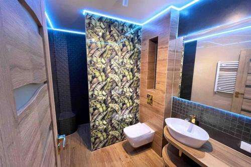 ein Badezimmer mit einem Waschbecken, einem WC und einem Spiegel in der Unterkunft Hawaii Beach Lounge, Loft z Jacuzzi i Tarasem - Słoneczne Tarasy w Porta Mare, Dziwnowek in Dziwnówek