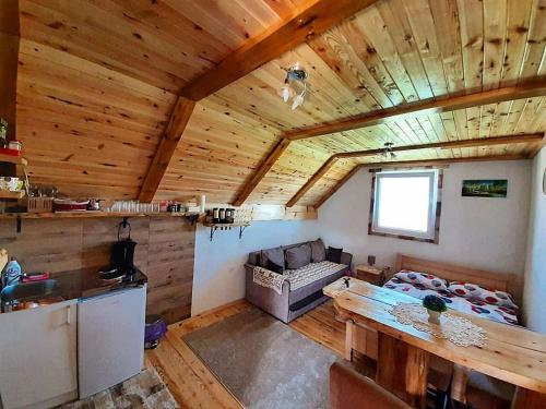 a kitchen and living room with a wooden ceiling at Durmitorski konaci apartments in Žabljak
