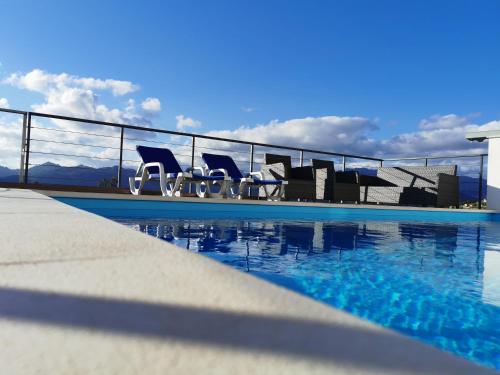 a group of chairs sitting next to a swimming pool at Casa Miradouro in Cova