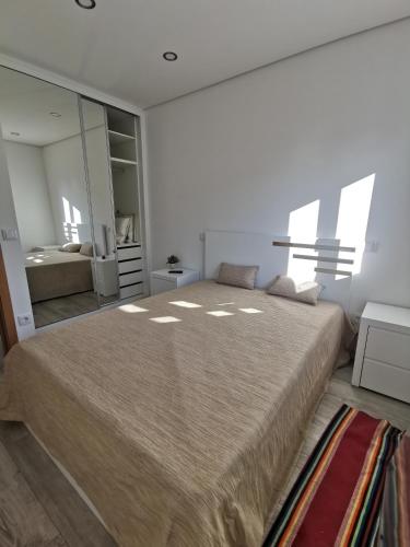 a bedroom with a large bed and a mirror at Casa Miradouro in Cova