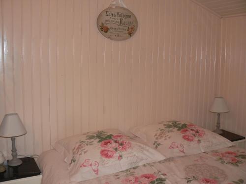 a bed with two pillows and a clock on the wall at chambre insolite dans un chalet in Sampigny