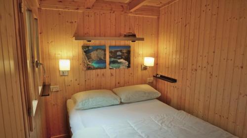 Giường trong phòng chung tại VAKANTIEHUIS CASASinPORLEZZA - Camping Italië
