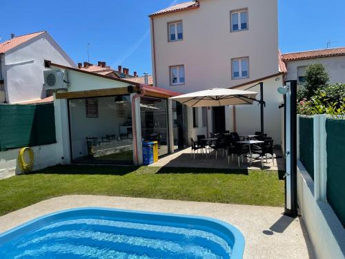 a swimming pool in a yard next to a house at Pension San Anton in Melide