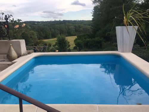 - une piscine bleue avec vue sur la campagne dans l'établissement Chateau Gros Puy, Petit Chateau chambre d'hote, à Abjat