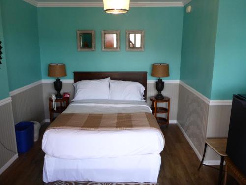 a bedroom with a large bed with blue walls at Charlroy Motel in Seaside Park