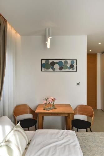 a bedroom with a table and chairs and a bed at Luxury Aparthotel Zadar in Zadar