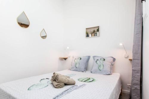 ein weißes Schlafzimmer mit einem Bett mit Handtüchern darauf in der Unterkunft Charming Appartement III in Antibes