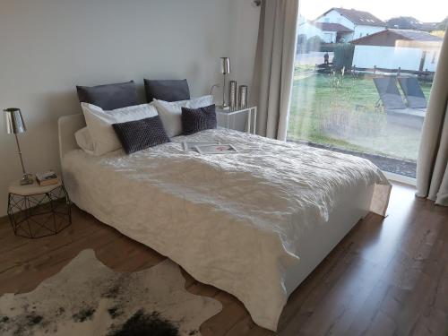 ein Schlafzimmer mit einem Bett und einem großen Fenster in der Unterkunft Ferienwohnung Auszeit Im Haag in Losheim