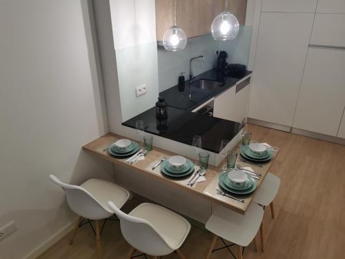a kitchen with a table with chairs and a sink at Apartamento Alto da Valeta in Arcos de Valdevez