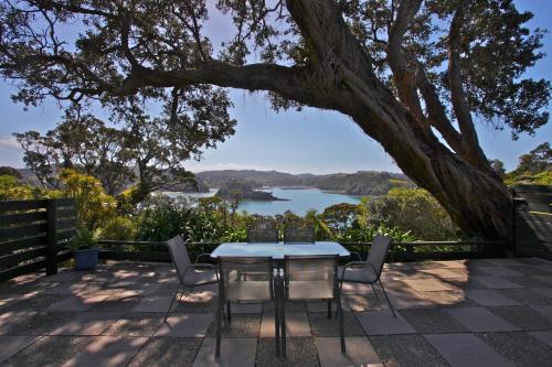 a table and chairs on a patio with a view of a lake at Pacific Rendezvous Resort in Tutukaka