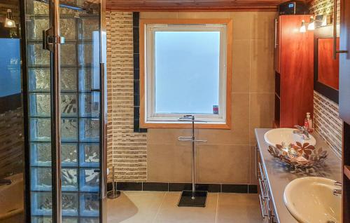 a bathroom with a shower and two sinks and a window at Skudeneshavn 182 Fish Camp in Syre