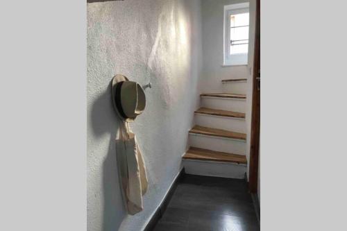 un couloir avec des escaliers et un sac en papier suspendu au mur dans l'établissement Ma Tour d'Auvergne _Charmant T2 avec vélos, à Châtel-Guyon