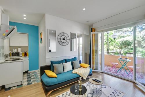 un salon avec un canapé bleu et une cuisine dans l'établissement - Luxury Appart Climatisé Plage -, à Cannes