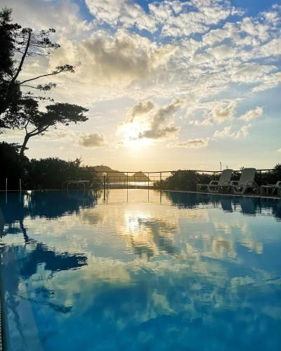 a large pool of blue water with a bridge in the background at Villa Anita Apartments in Capo dʼOrlando