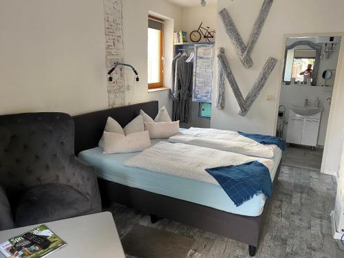 a bedroom with a bed and a chair in it at Ostsee Radlerpension Peitz in Peitz