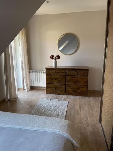 a bedroom with a dresser and a mirror on the wall at Willa Julianna in Mikołajki