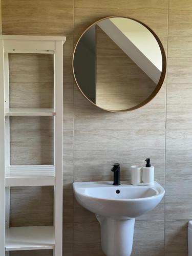 a bathroom with a white sink and a mirror at Willa Julianna in Mikołajki