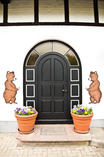 a black door with two flower pots in front of it at Das Bärenhaus in Bergen