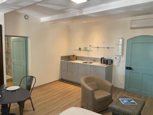 a kitchen with a chair and a table in a room at Carnets de voyage Coté studios in Lorgues