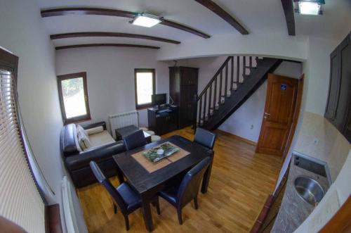 a dining room and living room with a table and chairs at Vila Darija Zlatar - studio apartman br. 3 in Nova Varoš