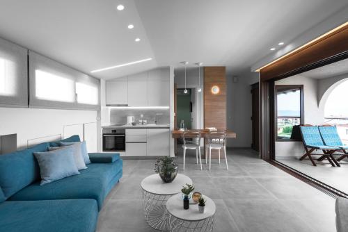 a living room with a blue couch and a kitchen at Pola's loft in Ierissos