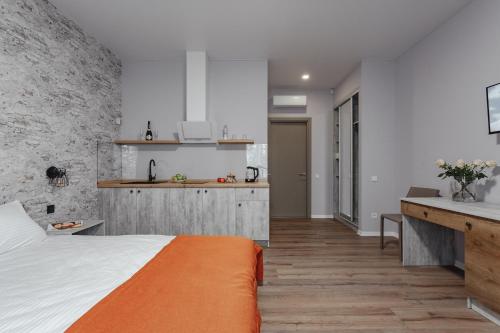 a bedroom with an orange bed and a kitchen at Fishel in Odesa